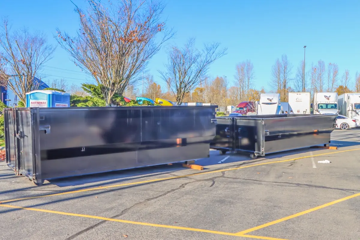 Professional dumpster rental service with roll-off container on residential driveway in Little Falls